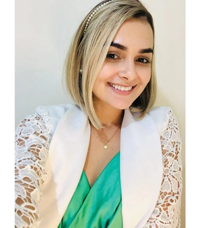 Jeniffer Baquião sorrindo, de jaleco branco